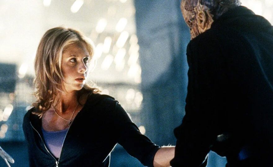 Buffy from the television series "Buffy the Vampire Slayer" holds a weapon in her hand and lunges at a monster.