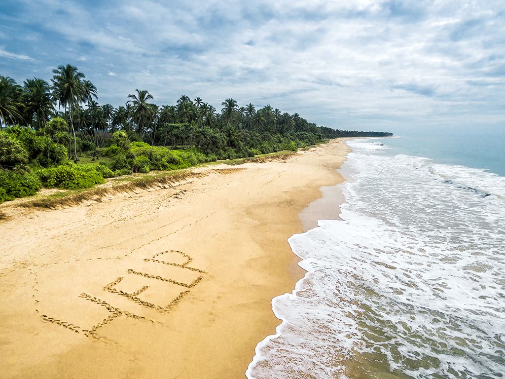 Help written in the sand on the beach