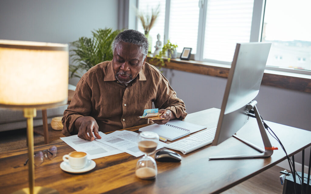 Older man looking at papers on desk