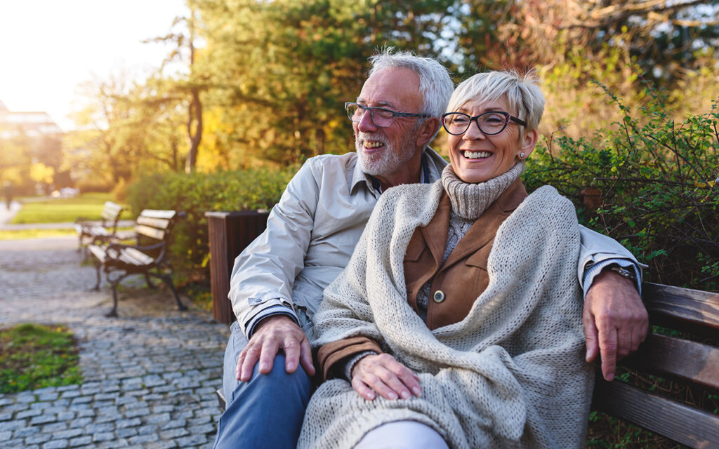 Elderly couple sitting on park bench