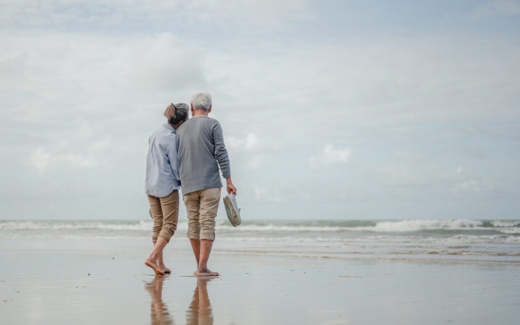 Elderly couple walking on beach