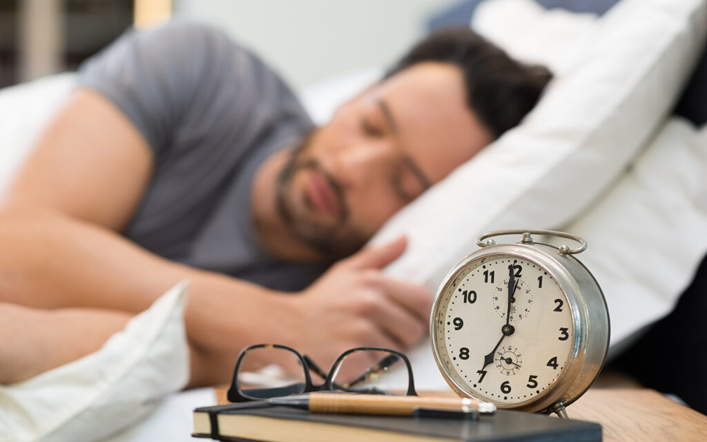 Man sleeping next to alarm clock