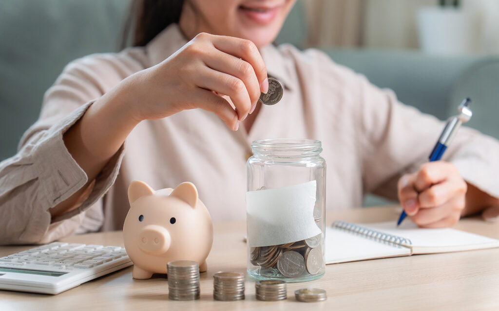 Woman saving money in a jar