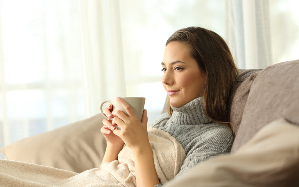 Woman drinking tea on a couch